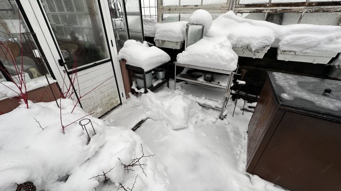 Utomhuskök och möbler täckta med snö, kallt vinter tempot, övergivet utrymme.