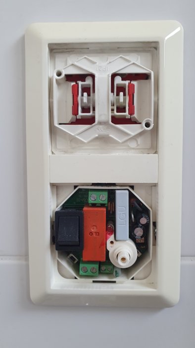 Öppnad elektrisk nätverkskabelanslutning med oanvänd RJ45-port och telefonjack, väggmonterad, obehandlad, innandöme exponerat.