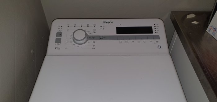 Vit Whirlpool tvättmaskin, kontrollpanel, programväljare, 7 kg kapacitet, energimärkning, inomhusmiljö.