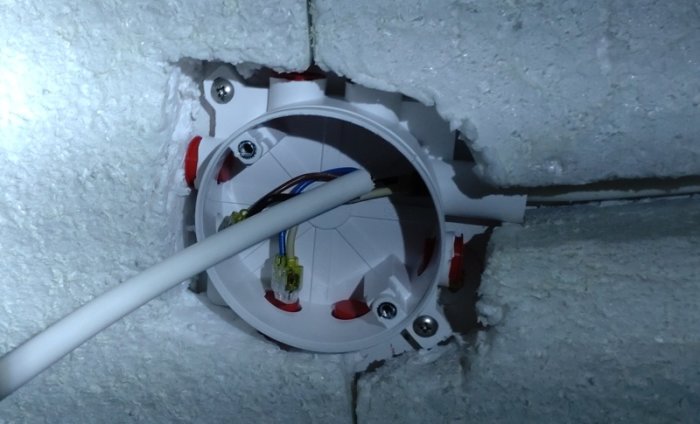 Eluttag utan front, kablar exponerade, monteringslåda i vägg, byggarbetsställe, elinstallation.