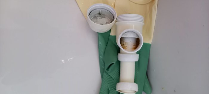 Avloppsrör, vattenlås delar, diskbänk, kök, avstängda gummihandskar, underhåll, reparation, vit bakgrund.