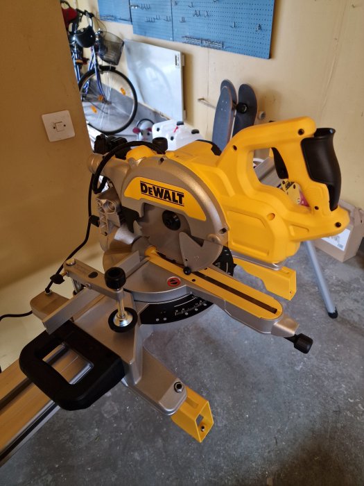Gul och svart DeWalt geringssåg i en verkstad med cykel och skateboard i bakgrunden.