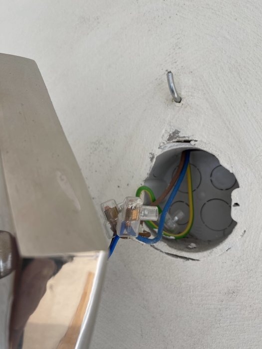 Elektrisk installation, öppen vägguttag, oskyddade kablar, terminalblock, delvis monterad, byggarbetsplats, installationsarbete pågår.