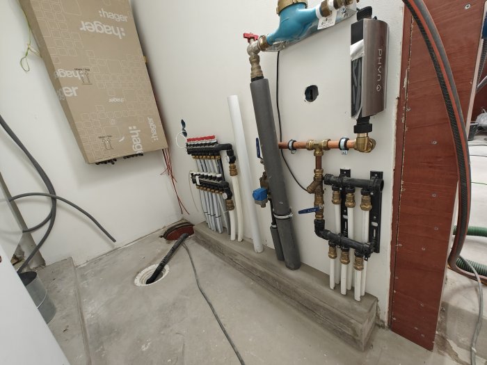 Installation för vatten och värme med rör, ventiler och elcentral i ett teknikrum.