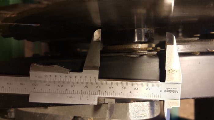 Skjutmått mäter metallkomponents dimensioner i en verkstadsmiljö. Precision, mätinstrument, teknik, verktyg, maskineri.