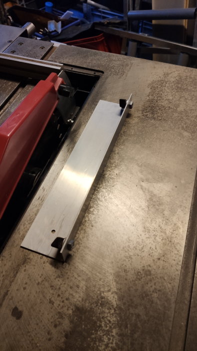 Industriell miljö med metallstycke på maskinbord, verkstad, arbetsplats, skärmoment, metallsågning eller bearbetning, tillverkning.