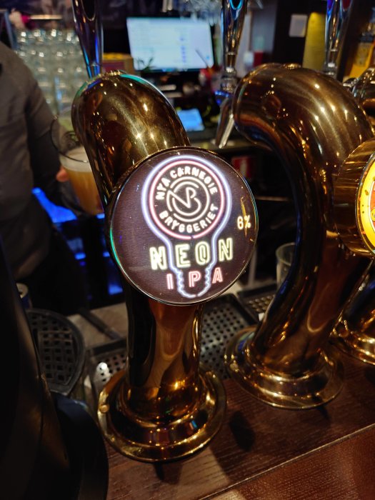 Ölöl tappkran med märket "Neon IPA" från bryggeriet "Nya Carnegiebryggeriet", 6% alkoholhalt, i en bar.