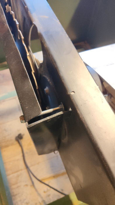Närbild av en maskindel, troligtvis en metallskärare eller fräs, i verkstadsmiljö med fokus på blad och mekanisk struktur.