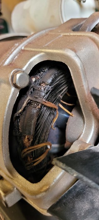 Bild på skadad bromsok med synlig kolvsprickning, rost och slitna bromsklossar, behöver reparation eller utbyte.