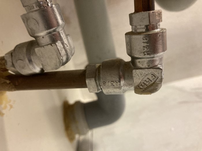 Rörkopplingar och ventiler i metall, troligtvis del av VVS-installation. Slitna, använda, lätt korroderade.