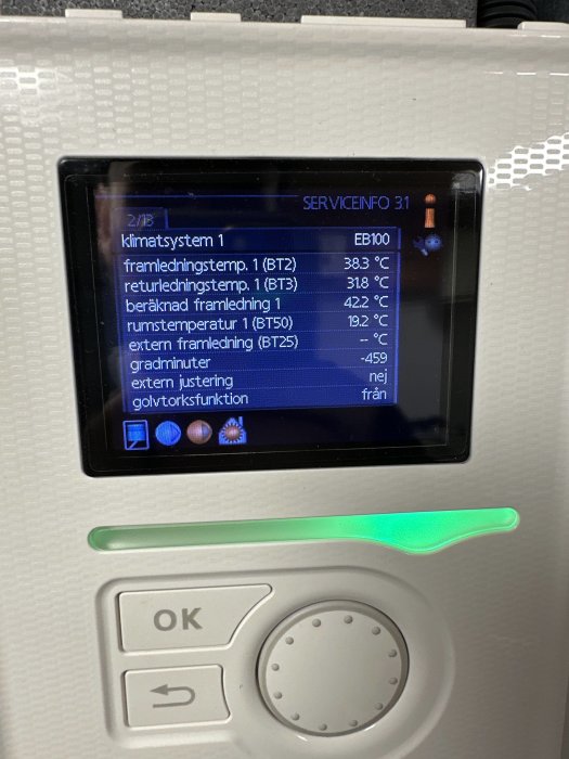 Digital display visar temperaturdata för klimatsystem, knappar, och grön statusindikator, eventuellt för en värmepump eller liknande.