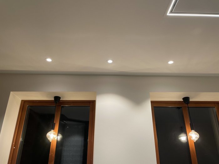 Modern inredning, infällda spotlights, dekorativ LED-slinga, träfönsterramar, retro glödlampor, inslag av minimalism.
