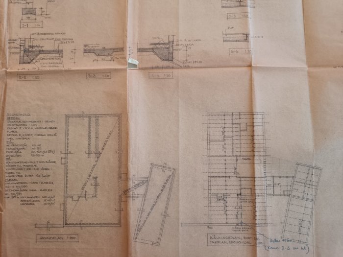 Arkitektoniska ritningar på brunt papper, byggdetaljer, planlösningar och sektioner, vikt i fjärdedelar, tekniska anteckningar.