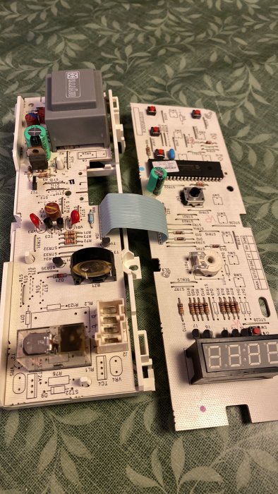 Demonterade elektroniska kretsar och komponenter på ett mönstrat underlag.