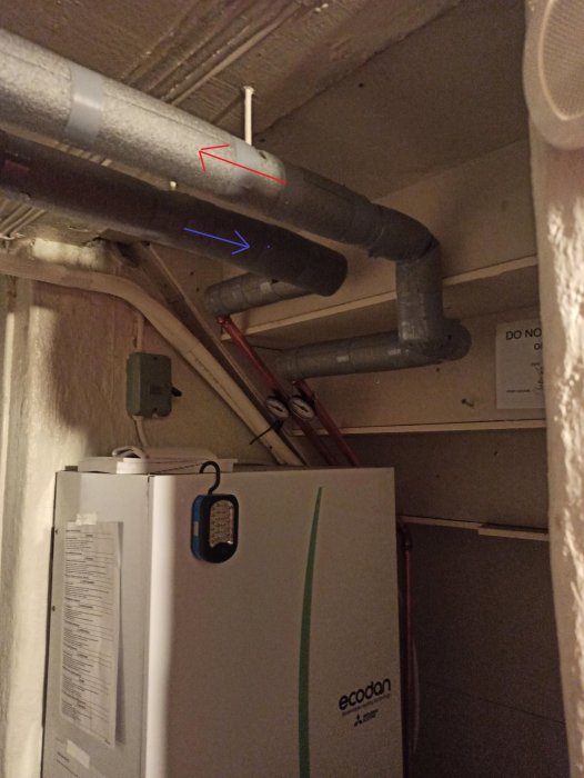 Källarrum med värmepump "Ecodan", rör, isolering och varningsskylt "DO NOT COVER".