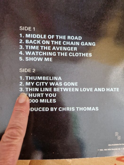 Finger pointing at album tracklist with Side 1 and 2, produced by Chris Thomas, dated 1982.