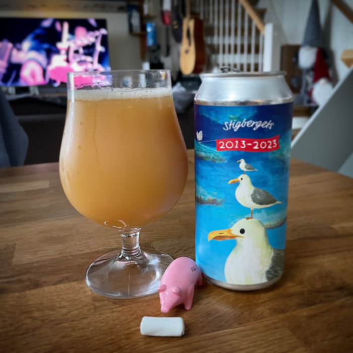 Öl i glas, burk med fåglar, bakgrund med tv och gitarr, liten rosa leksaksgris och tuggummi på bordet.