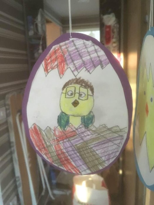 Barnritning av person på äggformat papper, hängande dekoration, färgglad, hemmiljö, kreativ, påsktema.