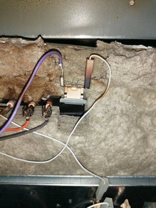 Slitna elektriska komponenter och kablar i dammigt isolerat utrymme. Behöver underhåll eller reparation.