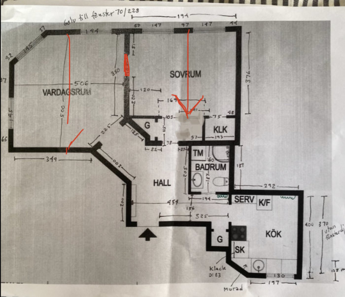 En ritad planlösning av en lägenhet med mått och handskrivna anteckningar, inkluderar vardagsrum, sovrum, badrum, kök.