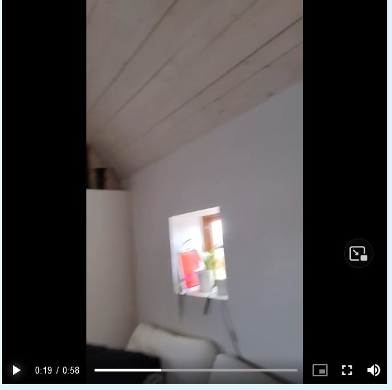 Oskarp inomhusbild, vit vägg, takbjälkar, fönster, vit soffa, speltidsmarkör, video-uppspelningskontroller.