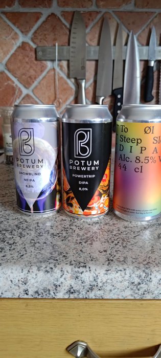 Tre ölburkar på köksbänk framför knivmagnet. Olika ölsorter och styrkor från Potum Brewery.