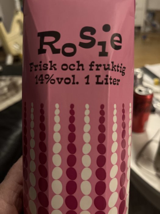 Rosa förpackning med text "RoSie", beskriver drycken som "Frisk och fruktig", 14% alkohol, en liter.