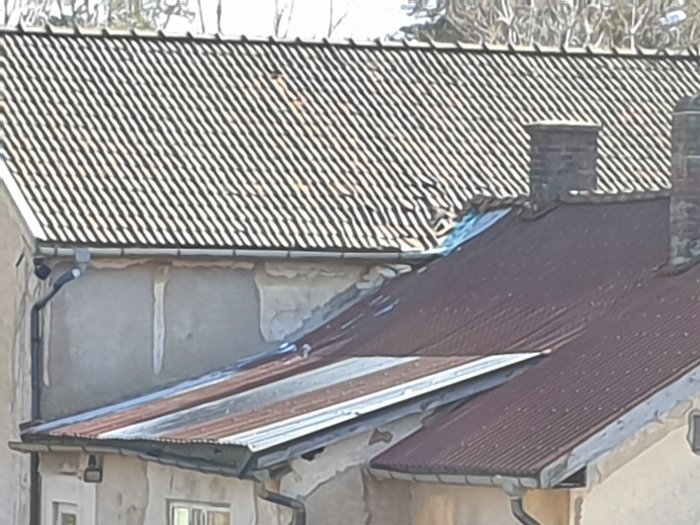 Byggnader med slitna tak, en del av takblecket är trasigt och hänger löst.