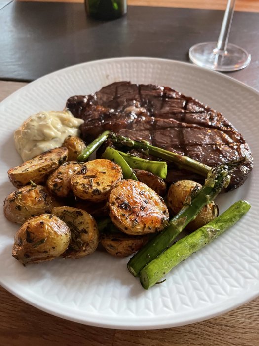 Grillad entrecôte, rostad potatis, sparris, bearnaisesås, vin, middagsdukning.