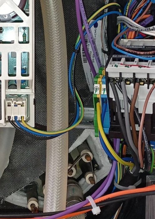 Inre del av en dator med kablar, kontakter och elektroniska komponenter synliga.