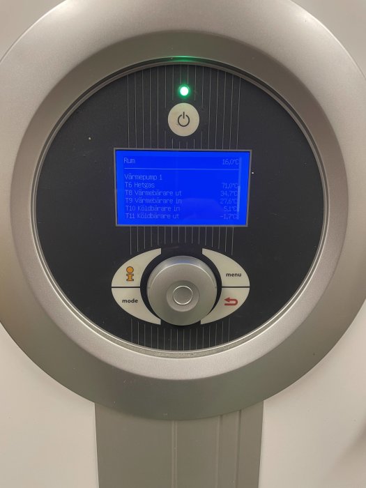 Digital display på värmesystem, visar temperaturer och status för värmepump och komponenter.