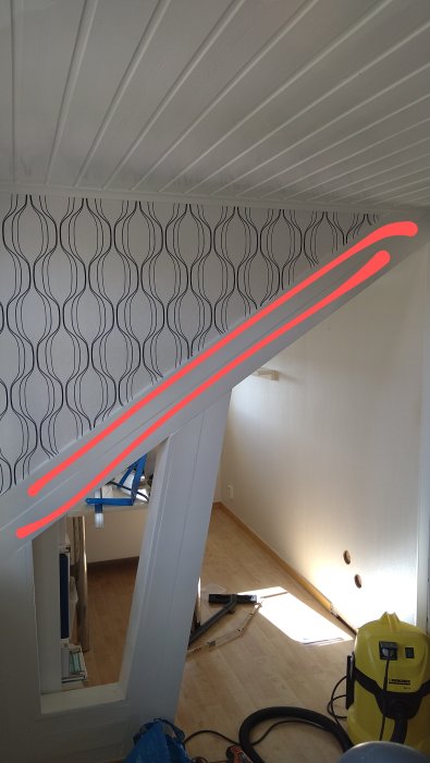 Inomhusrenovering, mönstrad tapet, vit takpanel, trappa, byggutrustning, golvstående vakuum, rör på golvet, konstruktionsmiljö.