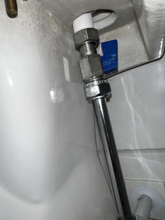 En bild på sanitetsrör i en vit plastmatta, med en blå etikett. Vattenanslutning eller avlopp synligt.