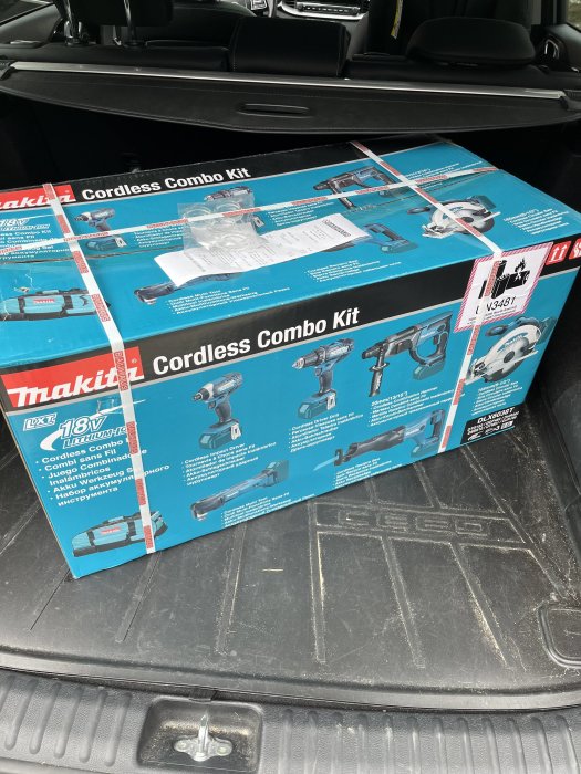 En Makita-cordless combo kit-låda i ett bilbagage. Verktygslådan inkluderar borr, såg och andra verktyg.