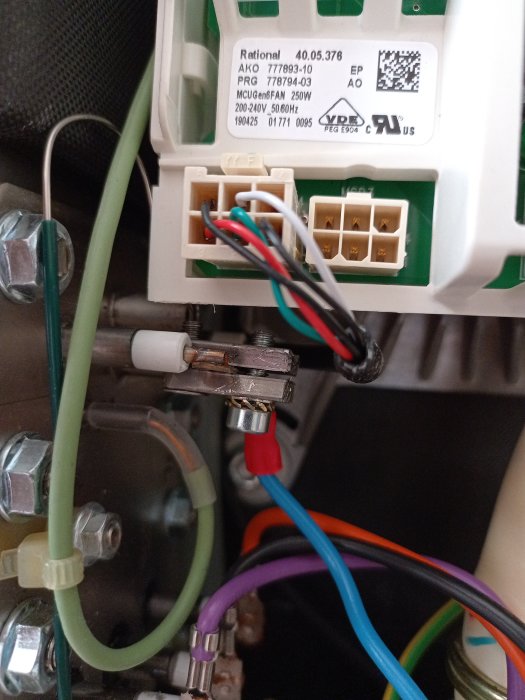 Elektriska komponenter och kablar inne i en apparat, sannolikt elektronik eller maskinutrustning.