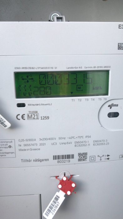 Elektricitetsmätare med digital display, säkringsplomb och diverse märkningar. Visar energiförbrukning i kilowattimmar (kWh).