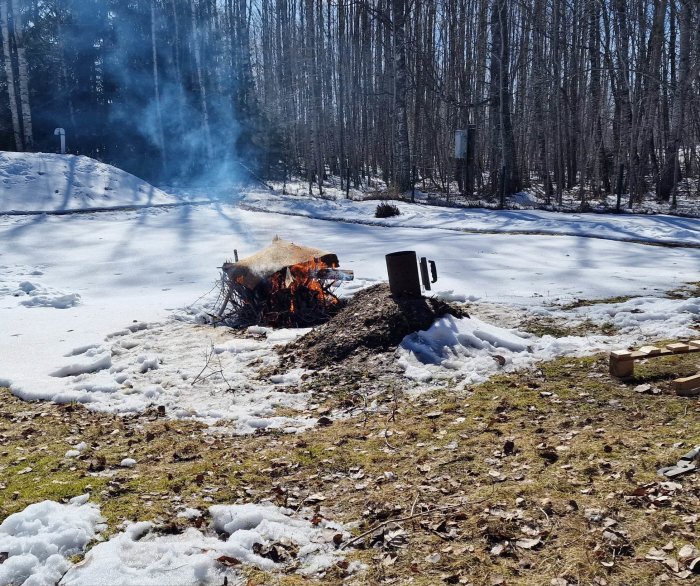 Brasa utomhus, smältande snö, skogsbakgrund, soligt väder, grill nära elden, vinter möter våren.