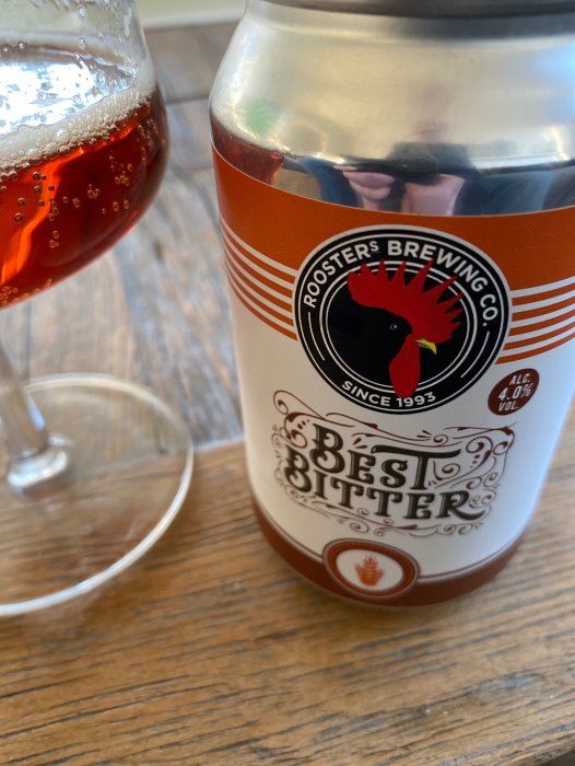 Ölburk från Roosters Brewing Co., Best Bitters, närbild, på träyta, med ölglas delvis synligt.