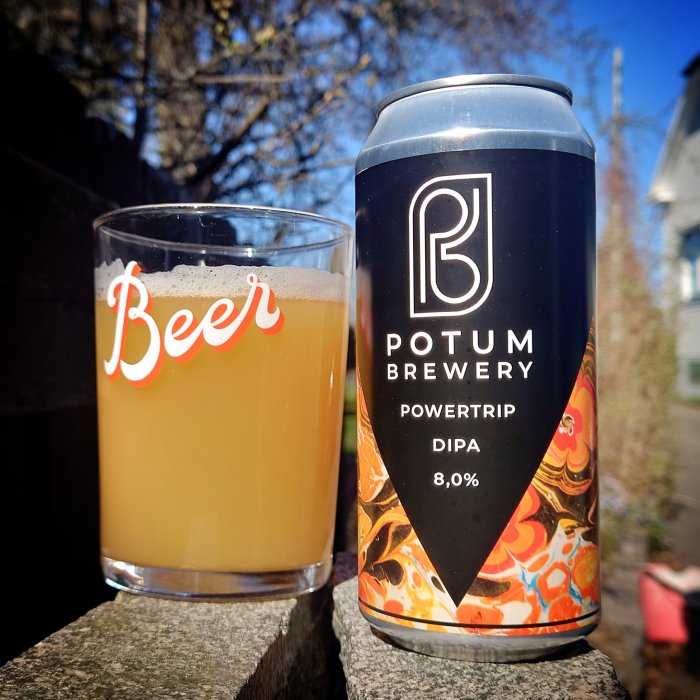 Öl i glas bredvid en burk från Potum Brewery, Powertrip DIPA, utomhus i solljus.