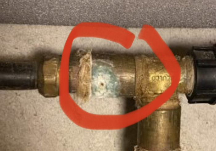 Gamla kopparrör med synliga korrosionstecken, röd markering runt området med mest slitage.