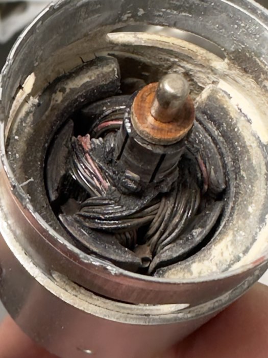 Sliten, smutsig elektrisk motor eller generator del, synliga koppartrådar, behöver reparation eller utbyte.