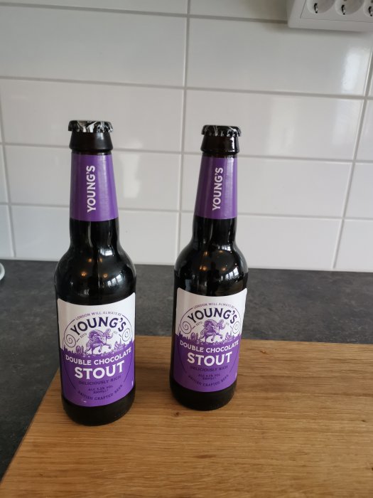 Två flaskor Young's Double Chocolate Stout på en bänkskiva framför kakelvägg.