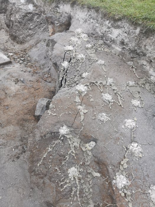 Erosion eller byggarbetsplats med spruckna betongytor och synliga jordskikt.