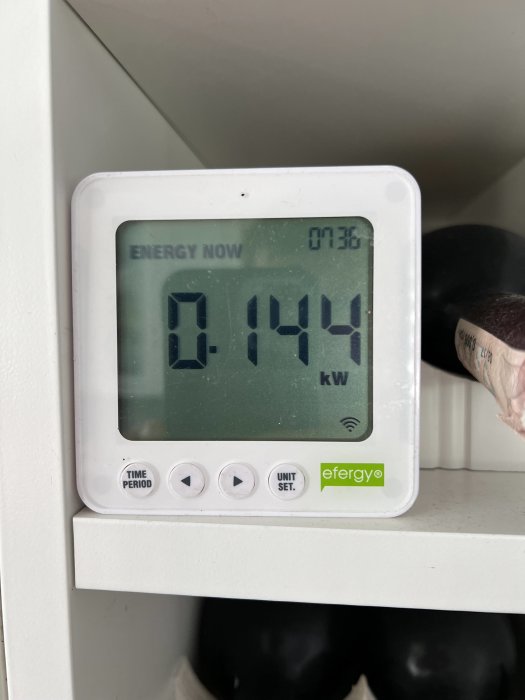 Digital energimätare som visar aktuell förbrukning på 0.194 kW, monterad på vit yta.