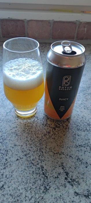 Ett glas med skummande öl och en uppöppnad burk från Potum Brewery på en köksbänk.