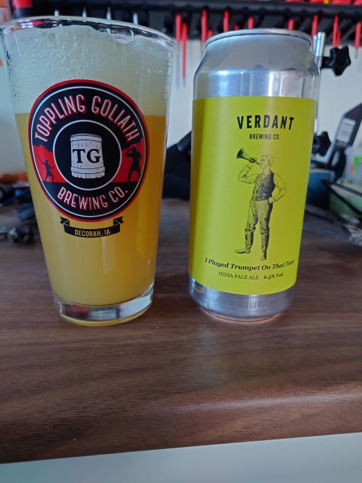 Ett ölglas med logotypen "Toppling Goliath Brewing Co." och en burk India Pale Ale från "Verdant Brewing Co."