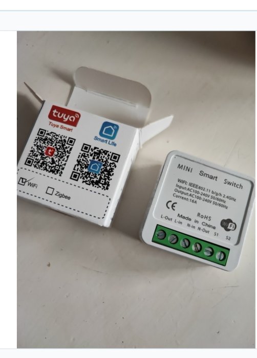 Öppnad vit förpackning och en smart strömbrytare med QR-koder och WiFi-symbol. Made in China.