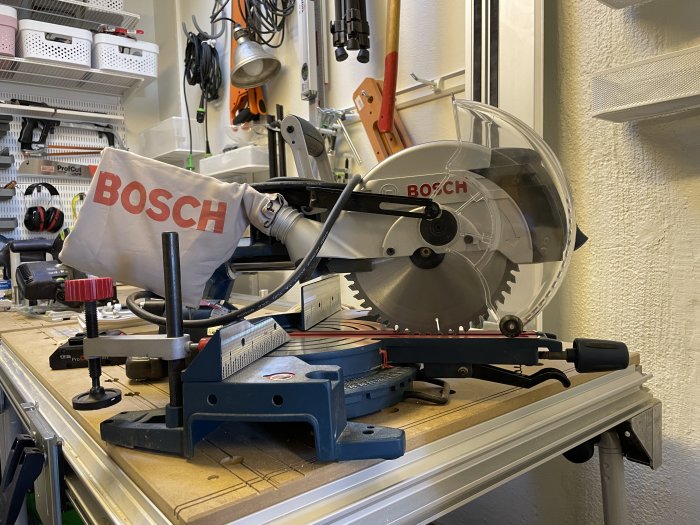 Verkstad med Bosch geringssåg på arbetsbänk, verktyg och organiseringsenheter i bakgrunden.