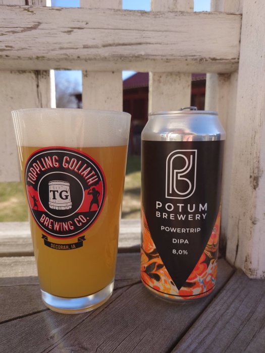 Ölglas med ölsorten från burk, ute på träbalkong, dag, Potum Brewery, Toppling Goliath, skum, alkoholhalt noterad.