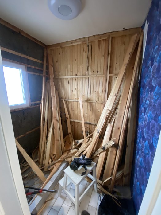 Renoveringsprojekt i pågång, trästomme exponerad, rörigt, avrivna delar, byggverktyg synliga, inomhusarbete, ombyggnad.